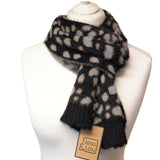 A fuzzy knit scarf with a black base and beige and gray leopard spots, displayed on a white mannequin bust. A paper tag with the brand name 'Jess & Lou' is attached.