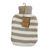 A striped hot water bottle wrapped in a ribbed knit turtleneck cover, hanging on a wooden hanger against a plain off-white background. The cover has alternating beige and off-white horizontal stripes, and a paper brand tag reading 'Jess & Lou' is attached.
