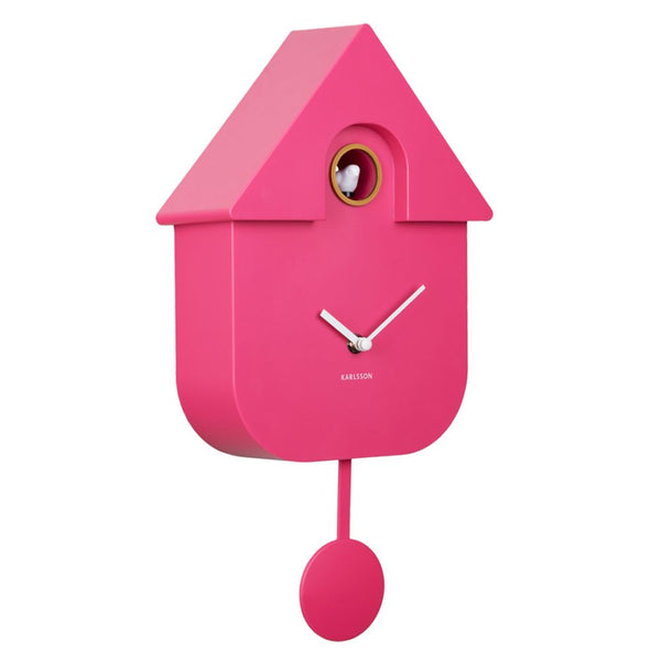A bright pink house-shaped cuckoo clock with silver hands and a pink pendulum, shown against a plain white background. The brand name 'KARLSON' is printed below the clock face.