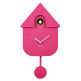 A bright pink house-shaped cuckoo clock with white hands and a small white bird window detail, shown against a plain white background. The brand name KARLSSON is printed below the clock face.