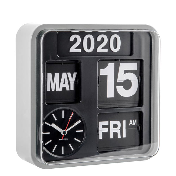 A modern square flip clock with a clear outer frame, black face, and white text showing the year 2020, the 15th of May, Friday, and AM. A small analog clock face is visible on the lower left with the brand name Karlson.