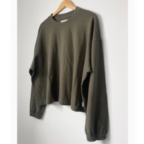 A green, crew neck t-shirt on a hanger, displaying a slightly boxy fit with elastic ruched sleeves.
