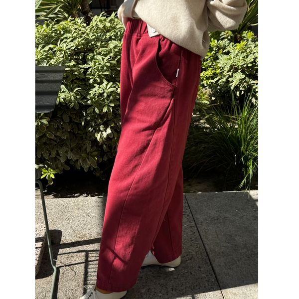 Le Bon shoppe Arc Pants in Oxblood from a side view shown with a cream sweater and shoes 