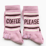 Pink socks with 'Coffee Please' text on a white background