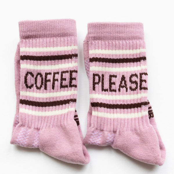 Pink socks with 'Coffee Please' text on a white background