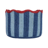 A hand-knit circular basket with vertical stripes in navy, light blue, and white, finished with a scalloped red rim, shown on a plain white background.
