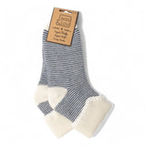 A pair of crew socks with navy and white horizontal stripes and cream-colored fleece foot cuffs, attached to a brown paper brand tag that reads 'less & lou'.
