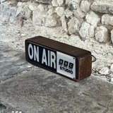 On-air BBC Studio microphone against a stone wall