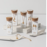 One & Eight Gold Apollo Earrings in glass bottles