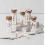 One & Eight Gold Apollo Earrings in glass bottles