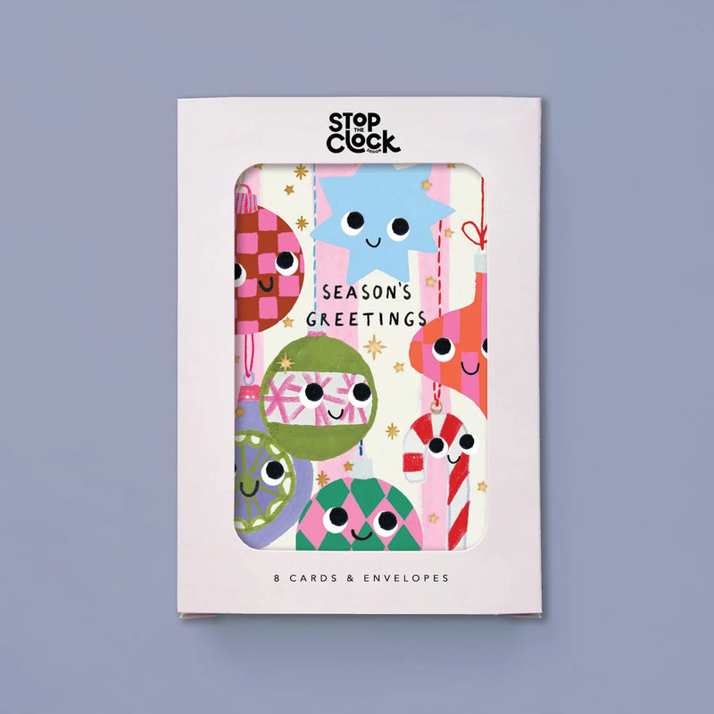 A boxed card set from Stop Clock featuring colorful, cute holiday-themed greeting cards visible through a clear window on the white packaging. The front reads 'SEASON'S GREETINGS' and '8 CARDS & ENVELOSES.