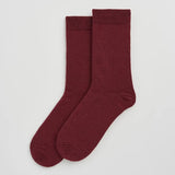 A pair of crew socks in a deep burgundy color, displayed flat against a light gray background.