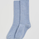 A pair of light blue ribbed knit crew socks displayed flat against a clean, light gray background.