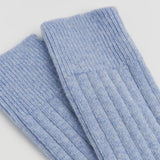 Pair of light blue ribbed socks on a light gray background