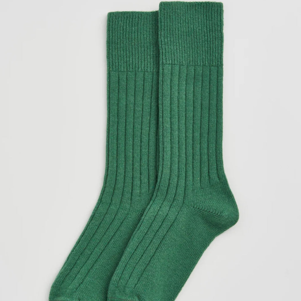 Pair of green socks on a light gray background