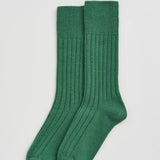 Pair of green socks on a light gray background