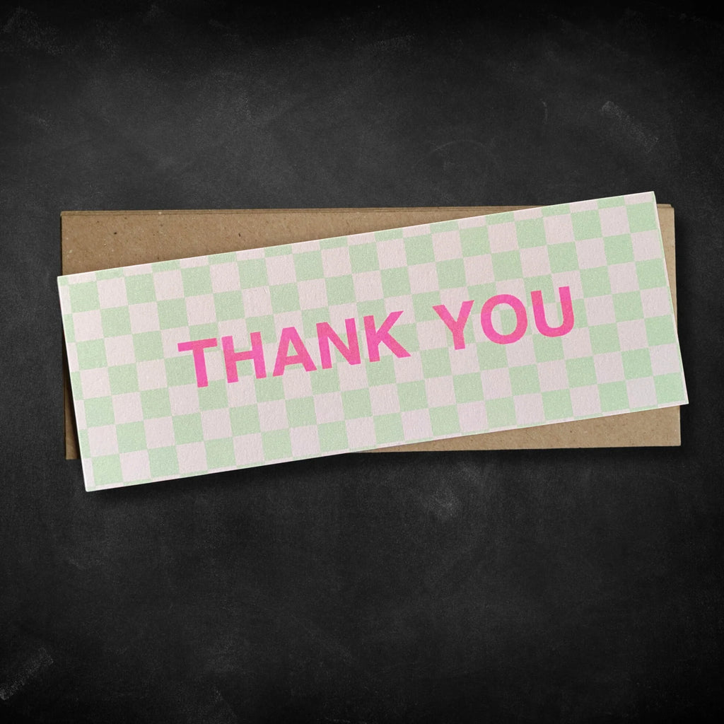 Checkered card with 'THANK YOU' in pink on a black background