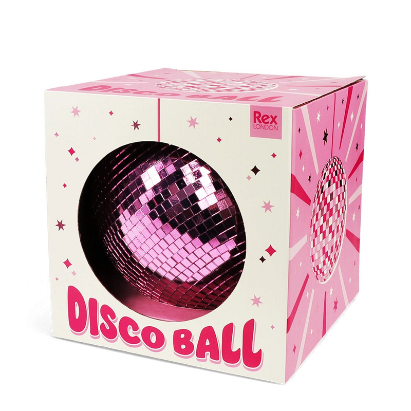 A pink and white cardboard box for a disco ball, featuring a large circular cutout on the front that displays a pink mirrored disco ball inside. The box is decorated with pink starburst patterns, stars, and the text 'DISCO BALL' in bold pink letters.