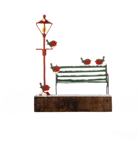 Decorative scene with a red lamp post, green bench, and four birds on a white background