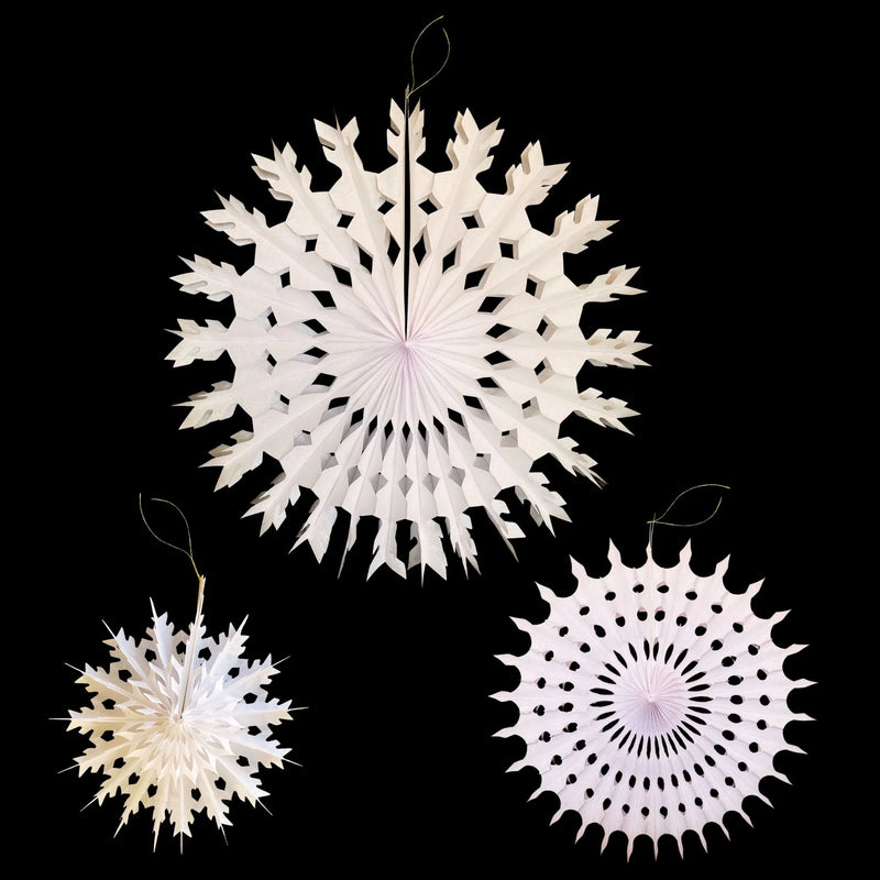 Three white paper snowflake hanging ornaments of different sizes displayed against a solid black background.