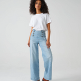 A model wearing high-rise, wide-leg blue jeans with sailor-style buttons at the front.