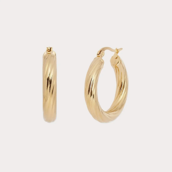 Gold hoop earrings on a light gray background