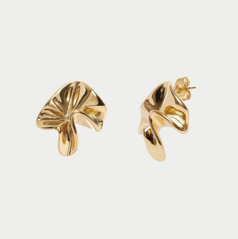 Gold leaf-shaped earrings on a light gray background