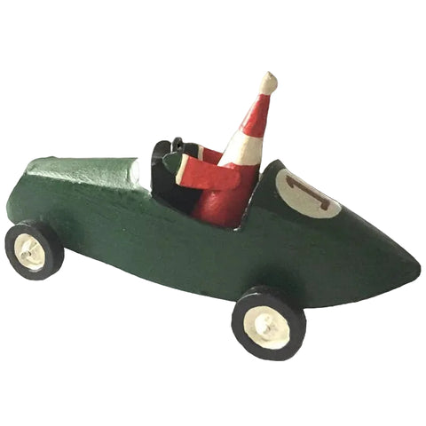 A small hand-painted wooden toy race car in dark green, with a red and white Santa hat driver and black wheels with cream-colored hubcaps, isolated on a white background.