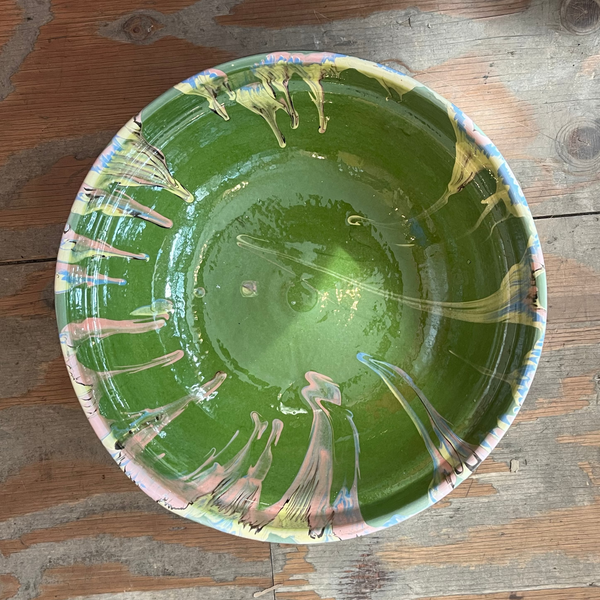 Green ceramic plate with abstract designs on a wooden surface