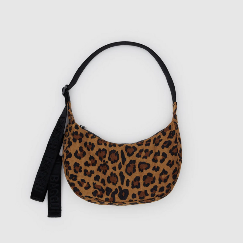 Leopard print handbag with a black strap on a light gray background