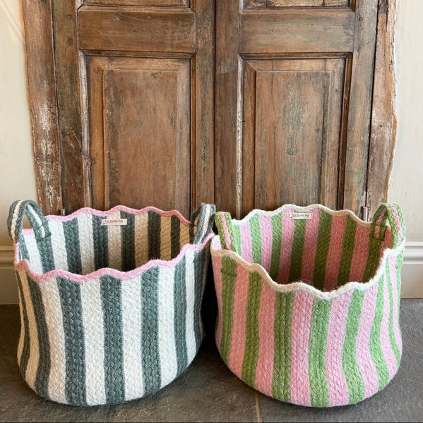 Two striped fabric baskets in front of a wooden door.