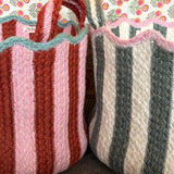 Two striped fabric baskets against a floral-patterned background