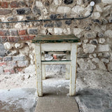 Vintage wooden stool against a stone wall