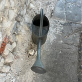 Metal watering can on a stone pavement