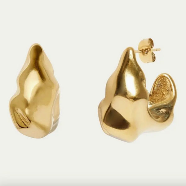 Gold earrings on a light gray background