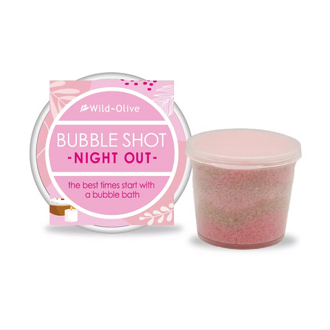 Pink bubble bath product with packaging labeled 'Bubble Shot Night Out' by Wild Olive on a white background.