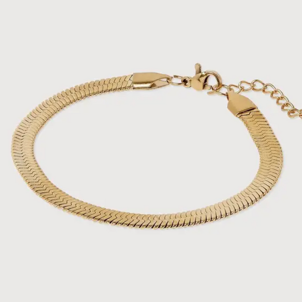 Gold bracelet on a light gray background