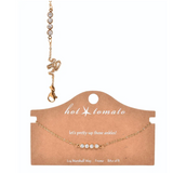 Gold bracelet with clear stones on a 'hot tomato' branded card