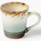 A ceramic mug with a gradient glaze transitioning from a warm cream interior to a speckled brown rim, a pale mint green middle section, and a dark brown base, shown on a white background.