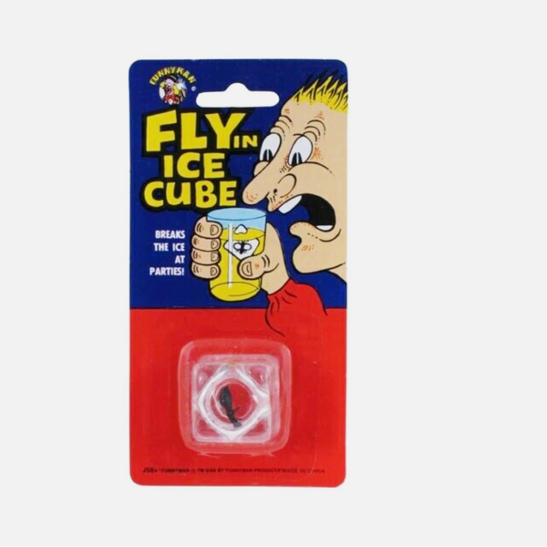 A novelty party ice cube in its original blister card packaging. The card features a cartoon illustration of a man with blond hair drinking from a yellow cup, with the text 'FLY IN ICE CUBE' on a blue background and a red lower section.