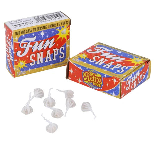 Two vintage-style boxes of 'Fun Snaps' novelty toys with several small white plastic snap-like pieces scattered in front, shown on a plain white background.