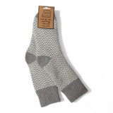 A pair of gray and white chevron-patterned crew socks with solid gray heels, toes, and cuffs, hanging from a brown paper brand tag on a white background.