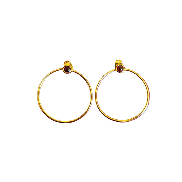 Gold hoop earrings with red gemstones on a white background