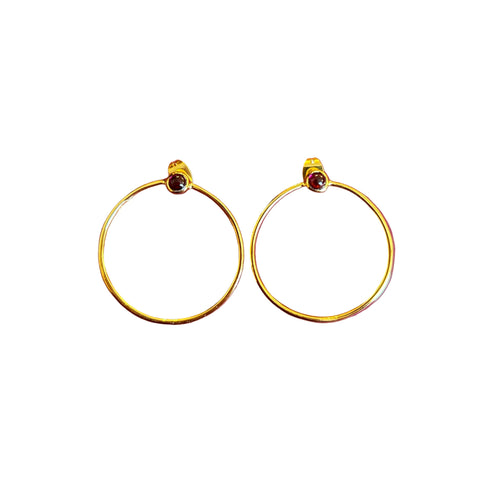 Gold hoop earrings with red gemstones on a white background