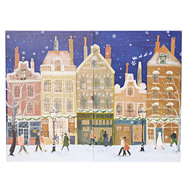A square art print or panel depicting a snowy winter street scene with colorful historic buildings, snow-covered rooftops, pedestrians, and a deep blue night sky with falling snow.