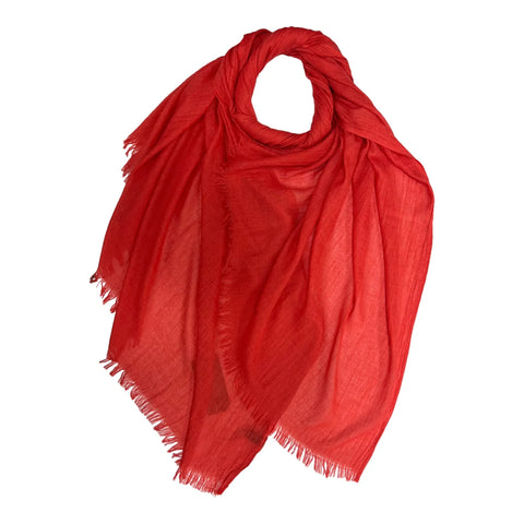 A vibrant red scarf with fringed edges, draped in a loose loop shape against a solid white background.