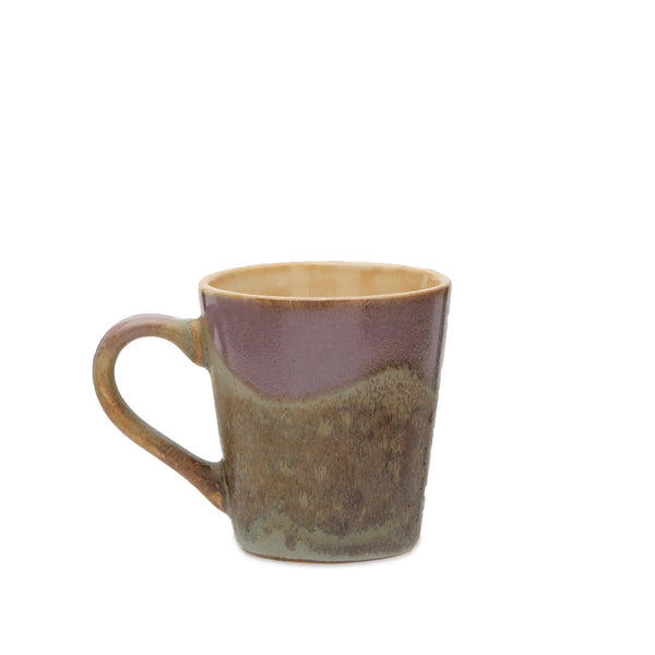 A handmade ceramic mug with a rustic, hand-painted glaze featuring a dusty purple upper section and a textured brown and green lower section, set against a plain white background.