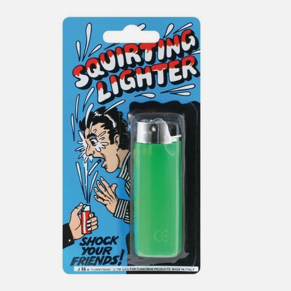 A green novelty squirting lighter in its original blue and white comic-style blister packaging, featuring the text 'Squirting Lighter' and an illustration of a shocked face.