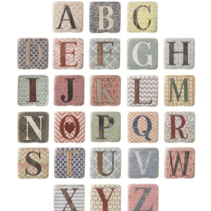 A set of square ceramic coasters, each with a letter of the alphabet in the center and a unique pattern around the edge.