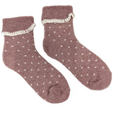 A pair of pink socks with small white polka dots and a cuff at the top, made from a wool-blend fabric.